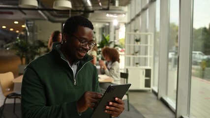 African american man smiling while using a digital tablet - Powered by Adobe