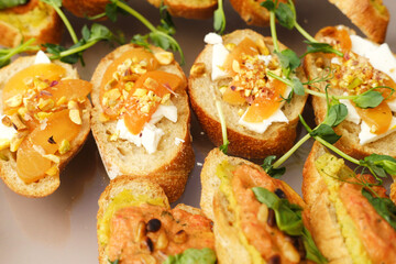 Gourmet appetizers featuring toasted bread topped with creamy cheese, dried fruits, nuts, and fresh herbs, beautifully arranged for an elegant dining experience