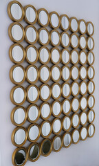 Decorative wall arrangement featuring multiple round mirrors in gold frames, creating a unique visual display that enhances interior aesthetics and reflects light beautifully