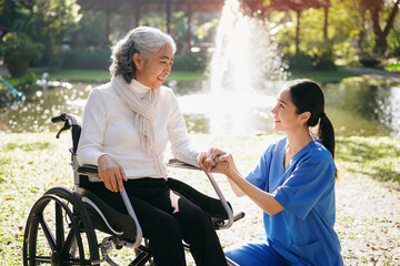 Fototapeta premium A woman in a wheelchair is being helped by a woman in a blue uniform