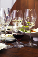 Leftover food and dirty dishes after an event, featuring empty wine glasses and plates, creating a scene of post-celebration cleanup and dining aftermath