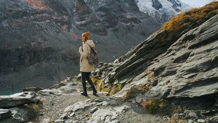 Hiker exploring rocky terrain in the mountains on a clear day with stunning views of peaks and...