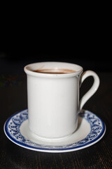 Traditional Mexican Champurrado in Ceramic Cup on Rustic Wooden Table