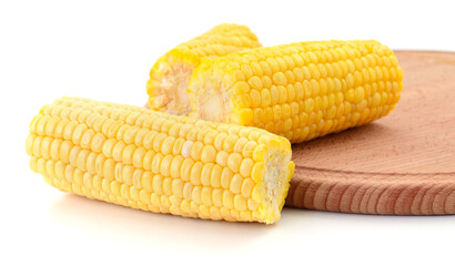 Boiled corn cobs on wooden board close-up