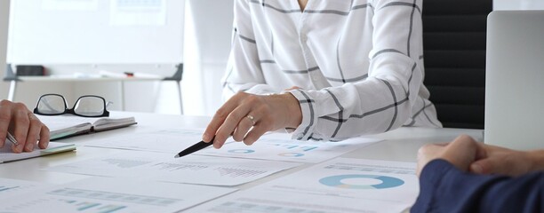 A business meeting with colleagues in a modern office where financial schedules, work planning, and reports are discussed in a team effort