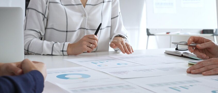 Business meeting with colleagues discussing financial charts, strategy planning, and analyzing data reports during a professional teamwork collaboration session