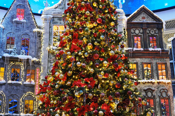 Beautifully decorated Christmas tree adorned with colorful ornaments and garlands, set against a festive shopping center backdrop, creating a joyful holiday atmosphere