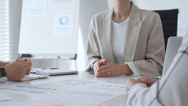Business people team discussing financial data and analyzing charts during a productive meeting in the office, focusing on collaborative teamwork and strategic decision making - Powered by Adobe