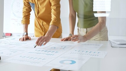 Professional business team members are reviewing financial data, analyzing charts and graphs, during a productive meeting in a modern office. Businesspeople concept