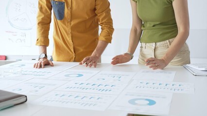 Business team members are reviewing financial data, analyzing charts and graphs, during a productive meeting in a modern office space