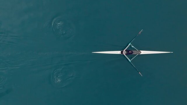 Rowing Top view of professional rower in racing boat, symbol of strength, determination and healthy active lifestyle. Single scull athlete training on water, in slow motion video 120fps.