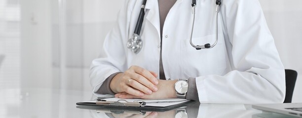 Doctor discussing medical treatment with patient during healthcare consultation, offering advice in...