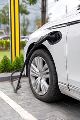 electric vehicle charger plugged into ev charging port - automotive and automobile concept