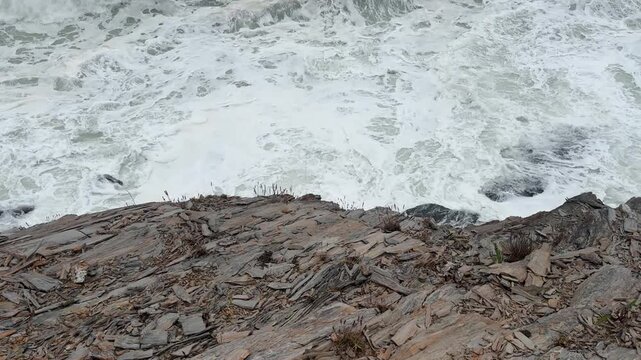 Large Rolling Waves Crashing Below Rocky Cliff