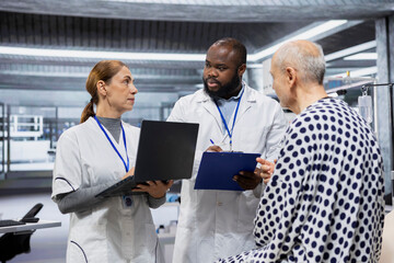 Fototapeta premium Diverse scientists performing observation and examination of a patient in a research lab, testing a new treatment and analyzing dosage effects. Studying risks and outcomes for progress.