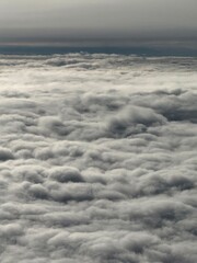 Obraz premium Close-up view of fluffy white clouds from airplane altitude. Beautiful aerial landscape with soft textures and bright daylight atmosphere