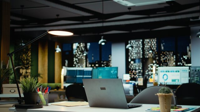 Modern business workspace glows with forecasting metrics and graphs. Corporate empty space equipped with technology and computers reflects administration of enterprise objectives.