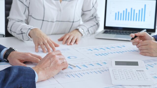Business people analyzing financial data and market trends during a corporate meeting, collaborating on reports and planning strategic growth in modern office