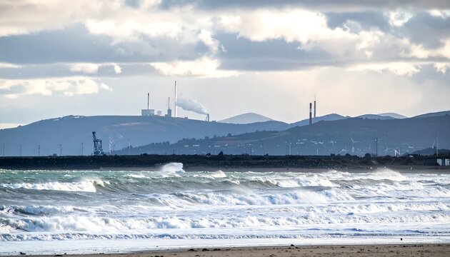 Coastal view with ocean waves crashing onto a sandy shore, mountains in background - Powered by Adobe