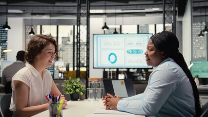 Female recruiter conducting interview with african american applicant, going through the hiring...