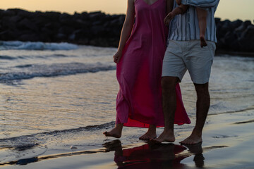 Couple in love walking on the beach at sunset. Love concept