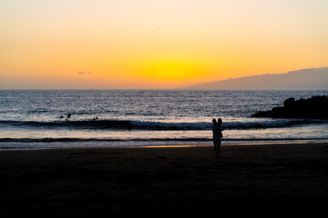Silhouette of a loving family on the beach at sunset.