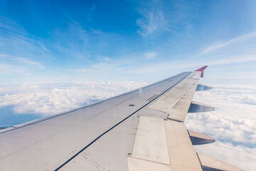 Obraz premium View from the airplane window at a beautiful cloudy sky and the airplane wing