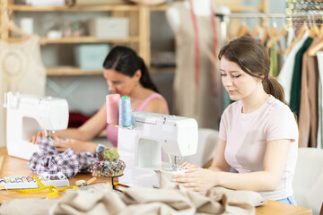 Two seamstresses working on sewing machines in a sewing workshop