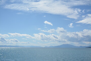 Beautiful seascape - calm blue sea, mountains and clouds