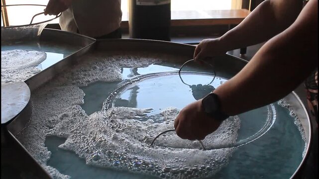 HOMBRE HACIENDO BURBUJAS GIGANTES EN UNA TINA CON JAB&Oacute;N