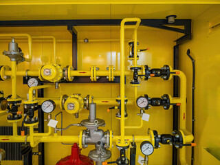 Gas distribution system with yellow pipelines, pressure gauges and valves, ensuring control and regulation in industrial and utility installations.