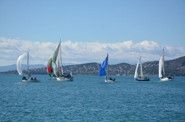 Fototapeta premium Yachts sail on the sea near the mountains on a windy day