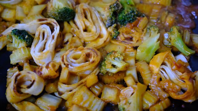 Stewing vegetables, broccoli, celery and filo pastry on cast iron, mixed vegetables steaming, cooking process, healthy meal, mediterranean food	