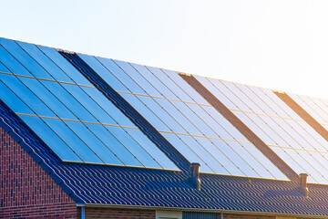 Close-up of rooftop solar panels in sunlight. House with solar photovoltaic panel system on roof....