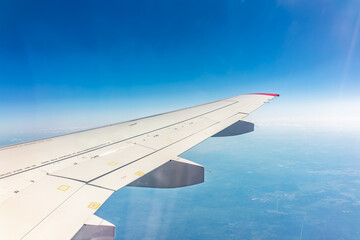 View from the airplane window at a beautiful blue clear sky and the airplane wing