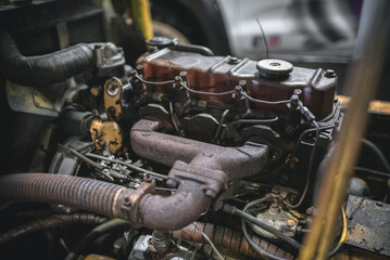 Detailed view of a vintage engine, highlighting the rusty exhaust system and mechanical parts.