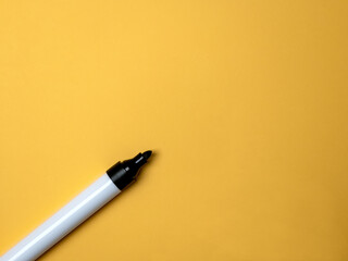 Black marker pen on a yellow background with copy space