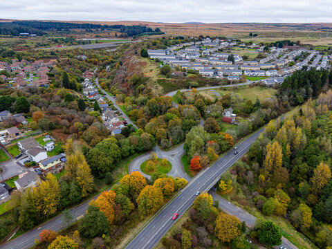 Roads and housing estates nestled in a Welsh valley with vibrant autumn foliage