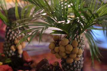 Fresh longan fruit served with pineapple is served with a tropical-themed ornament design.