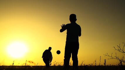 Boy child goalkeeper dad kicks ball, goal. Child son play football with father on lawn. Family team, sports games. Active happy family. Son dad having fun playing ball on green grass. Family kid sport