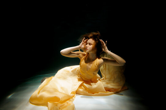 Fototapeta Discover the elegance of fashion with stunning underwater visuals in a dreamy yellow dress