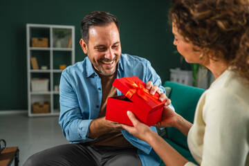 Woman giving present to man celebrating special occasion