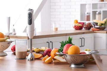 Fresh fruits and blender with healthy smoothie on kitchen table