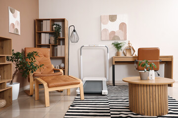 Interior of living room with treadmill, table and leather armchair with footstool