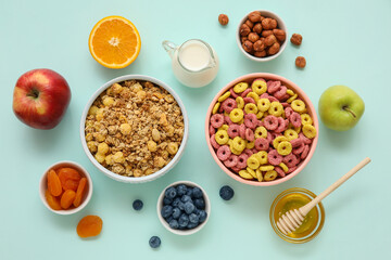 Bowls with different cereals and ingredients on turquoise background