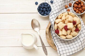 Bowls with corn pillows and ingredients on white wooden background