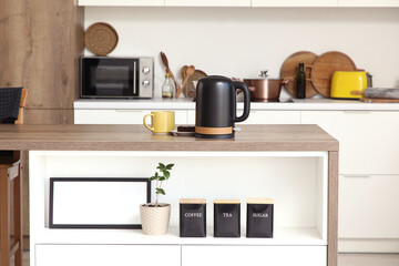 Black electric kettle on table in kitchen