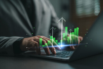 Businessman typing on laptop with glowing virtual stock market graph showing financial growth, investment analytics, performance metrics, and economic data visualization.