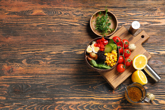 Composition with bowls of healthy quinoa salad and ingredients on wooden background
