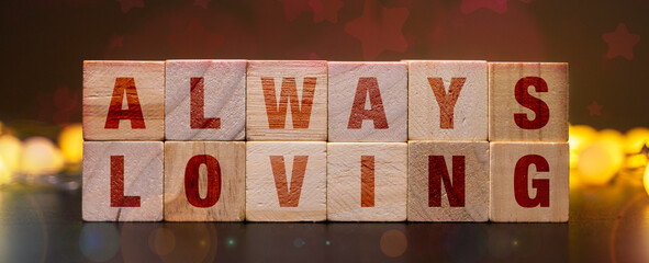 ALWAYS LOVING spelled out on wooden blocks, surrounded by warm, glowing string lights, conveying a...